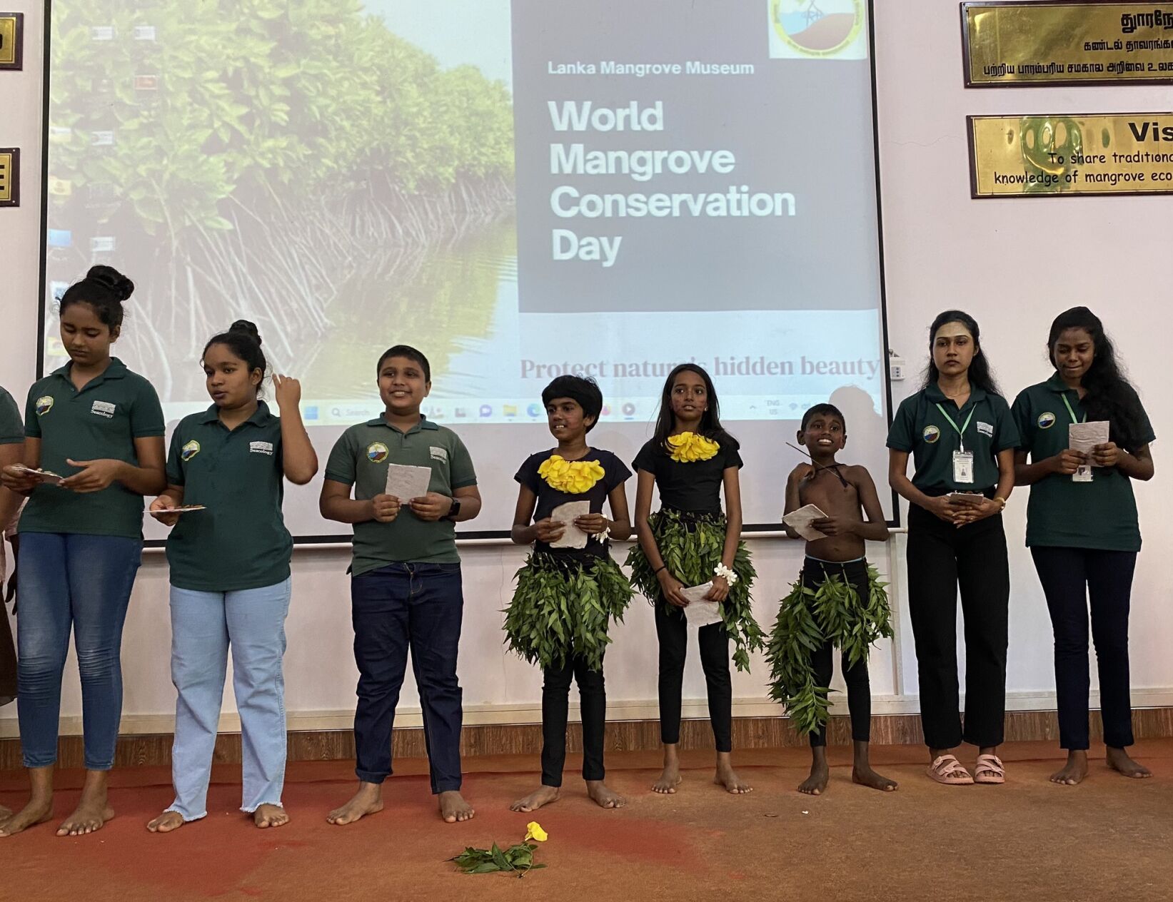 A group of young people giving a presentation on mangrove conservation